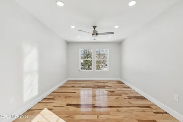 a view of a livingroom with wooden floor and a ceiling fan