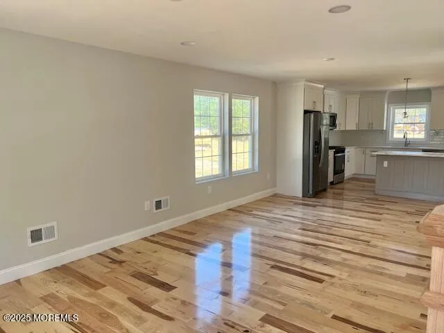 a kitchen with stainless steel appliances granite countertop a refrigerator a sink and a stove