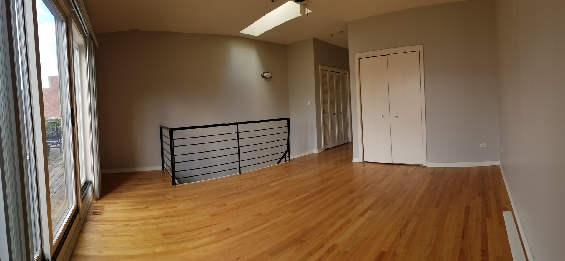1229 West Madison Street, Unit Q Chicago, IL 60607 - Photo 30 of 32 a view of an empty room with wooden floor and a window