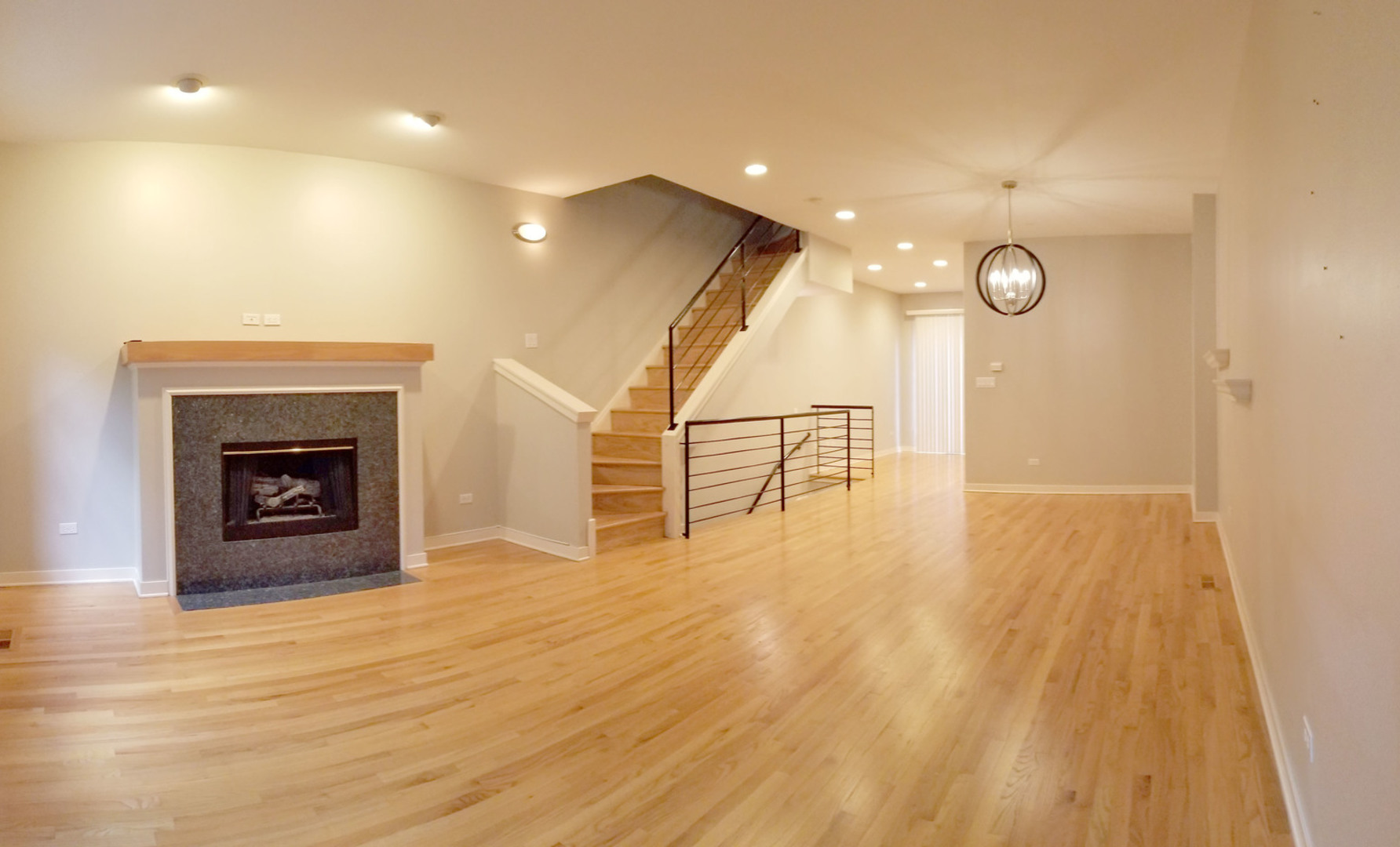 1229 West Madison Street, Unit Q Chicago, IL 60607 - Photo 6 of 32 a view of an empty room with wooden floor and a fireplace