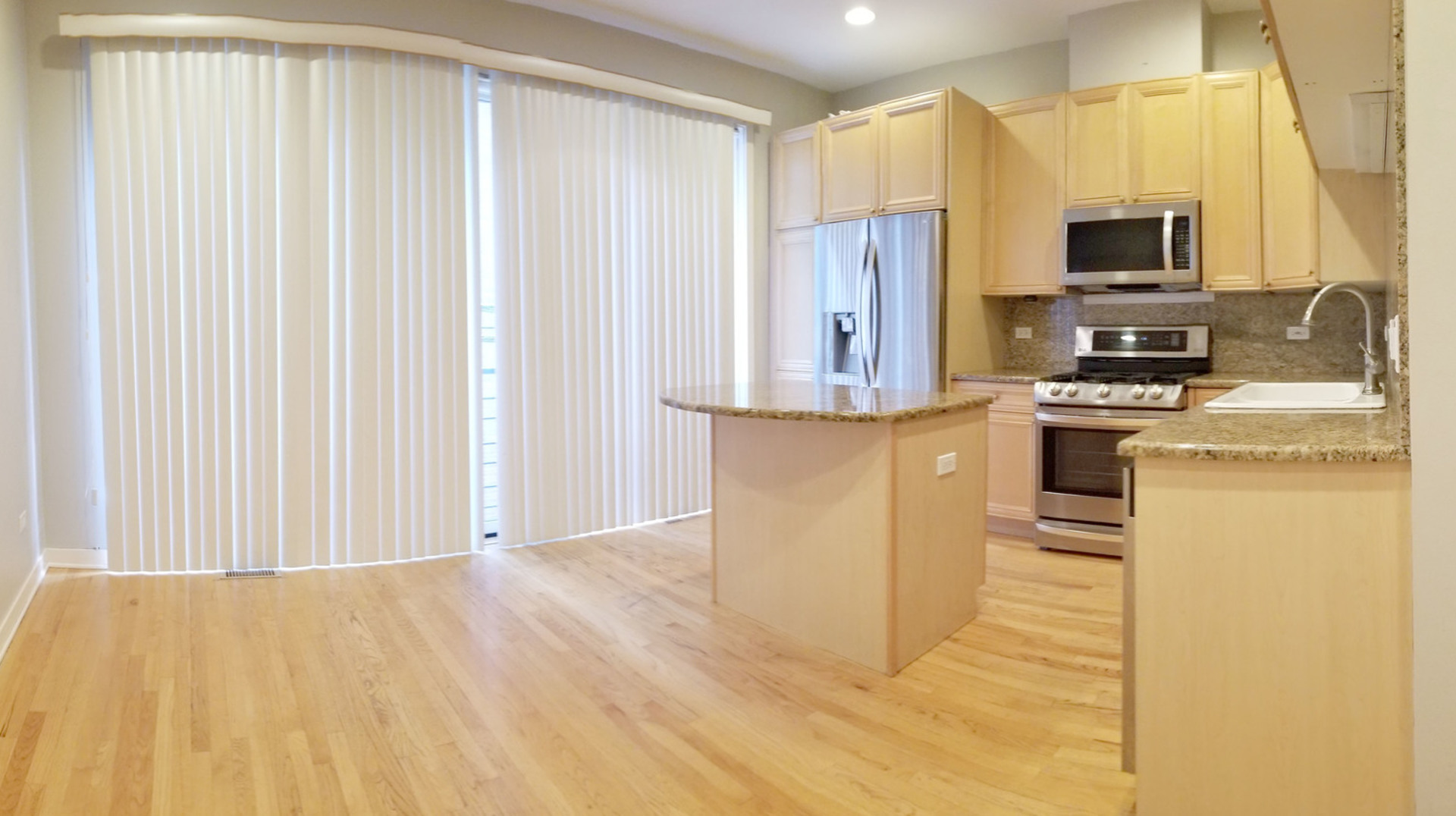 1229 West Madison Street, Unit Q Chicago, IL 60607 - Photo 8 of 32 a kitchen with stainless steel appliances white cabinets and a refrigerator