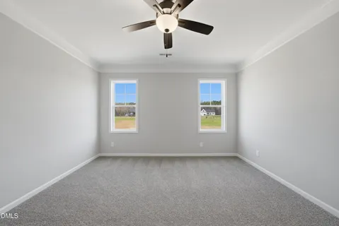an empty room with windows and ceiling fan