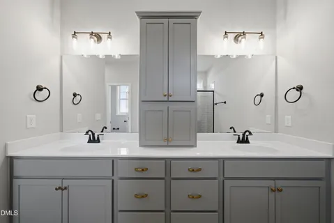 a bathroom with double vanity sinks and a mirror