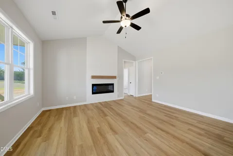 a view of empty room with fireplace and fan
