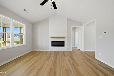 an empty room with windows and fireplace
