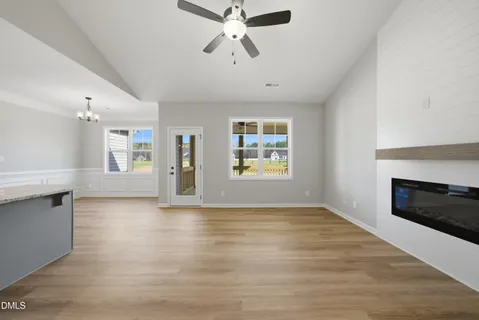 an empty room with windows and fireplace