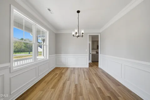 a view of a room with wooden floor staircase and a kitchen