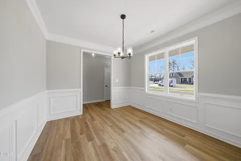 a view of a room with window wooden floor and front door