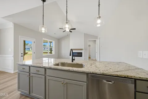 a kitchen with kitchen island granite countertop stainless steel appliances sink stove and microwave