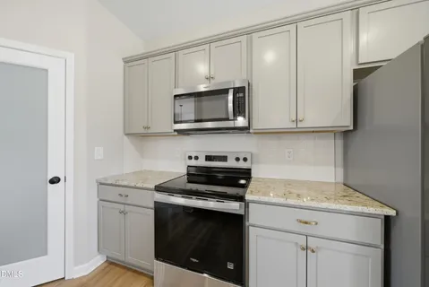a kitchen with granite countertop cabinets stainless steel appliances and a counter space