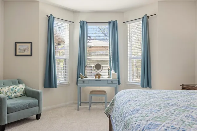 a bedroom with a bed and a couch next to a window