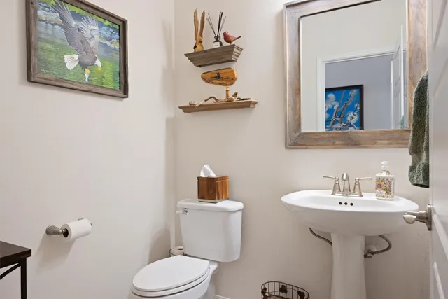 a bathroom with a toilet a sink and mirror