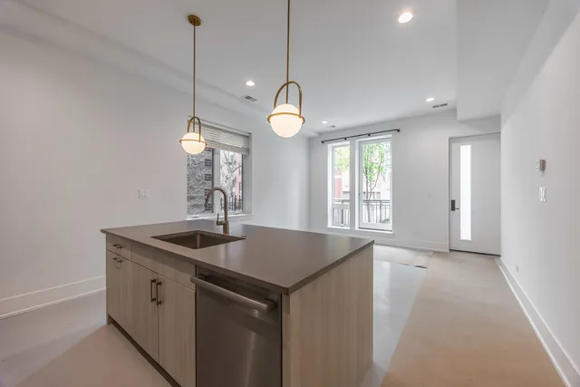 a kitchen that has a sink a window and cabinets