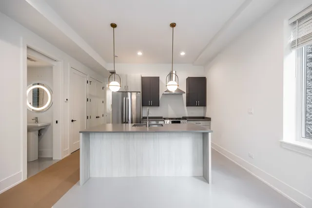 a kitchen with stainless steel appliances granite countertop a sink a stove and a refrigerator