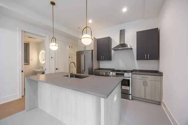 a kitchen with stainless steel appliances granite countertop a sink a stove a refrigerator and island