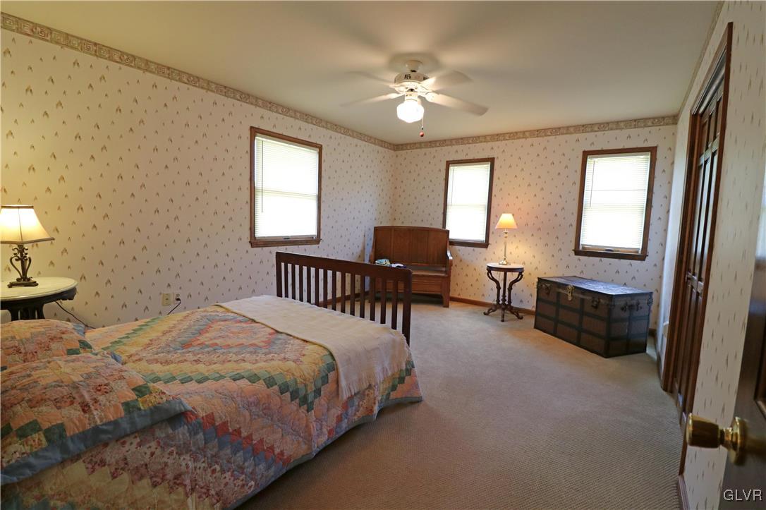 103 James Way Road Bath, PA 18014 - Photo 26 of 50 a spacious bedroom with a bed and a chandelier