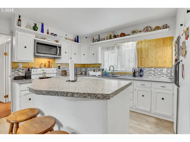 a kitchen with granite countertop a sink a stove and cabinets
