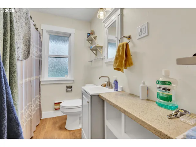 a bathroom with a sink vanity mirror and toilet
