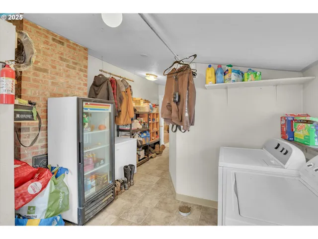 a utility room with fridge dryer and washer