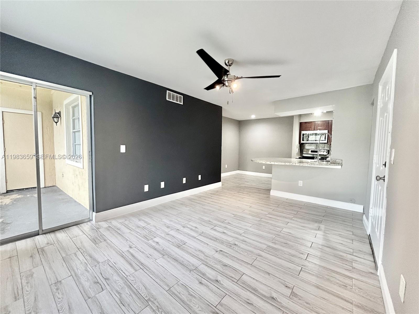 1263 Southwest 46th Avenue, Unit 2109 Pompano Beach, FL 33069 - Photo 2 of 18 a big room with wooden floor and windows