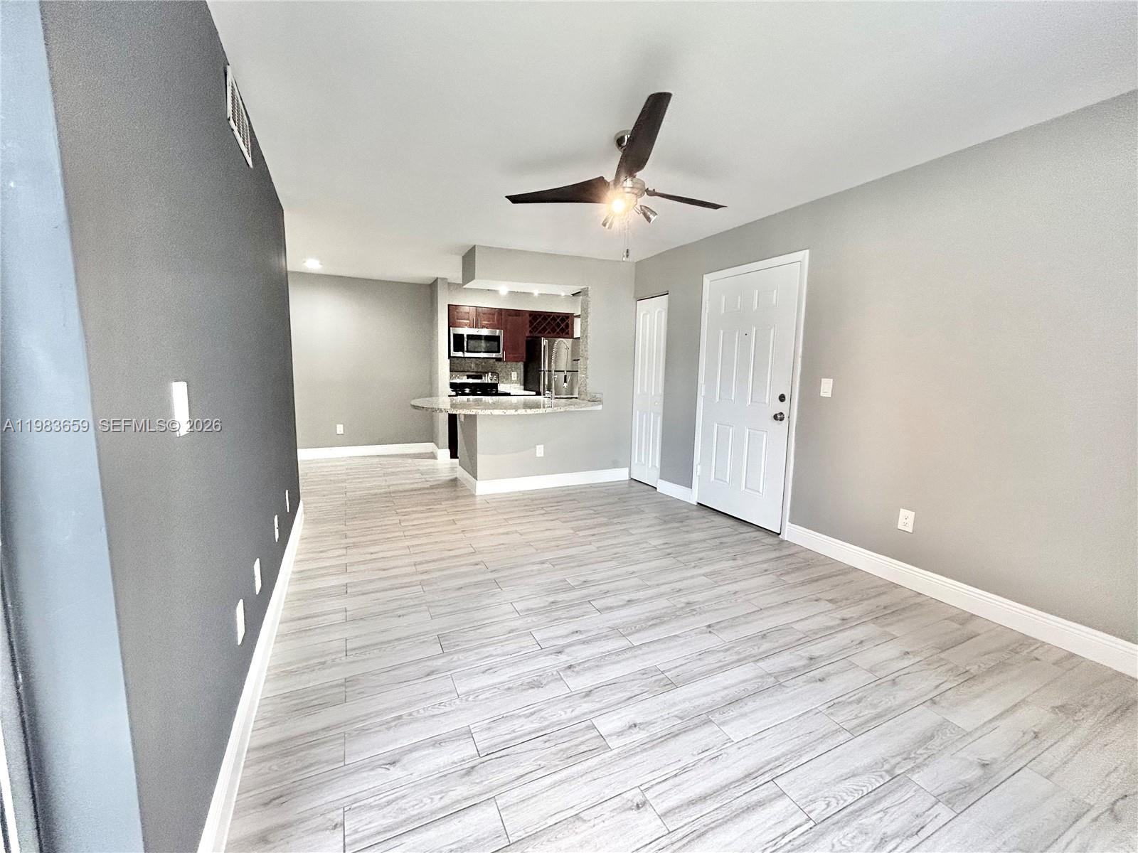 1263 Southwest 46th Avenue, Unit 2109 Pompano Beach, FL 33069 - Photo 3 of 18 a view of a livingroom with wooden floor and a ceiling fan