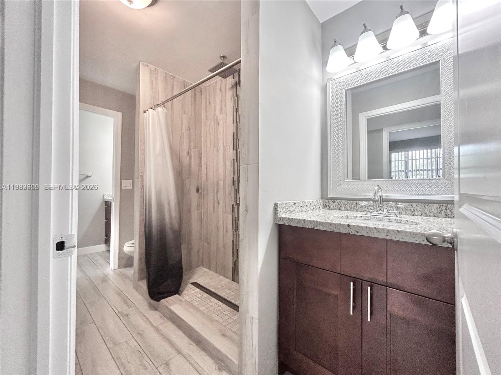 1263 Southwest 46th Avenue, Unit 2109 Pompano Beach, FL 33069 - Photo 5 of 18 a bathroom with a sink a mirror and a shower