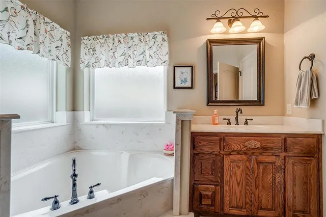 a bathroom with a bathtub sink and mirror
