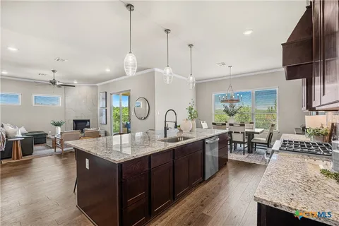 a kitchen with granite countertop a sink stove and wooden floor