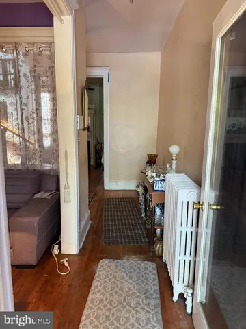 a view of a hallway with wooden floor and furniture