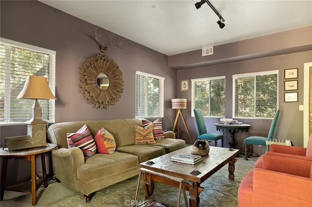 a living room with furniture two lamps and a large window