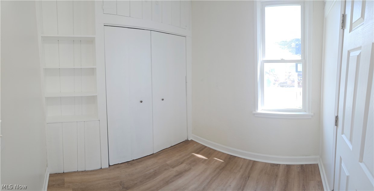 753 West River Road North Elyria, OH 44035 - Photo 8 of 28 Interior room featuring light wood-finish flooring, white walls, and bright natural light from a single window