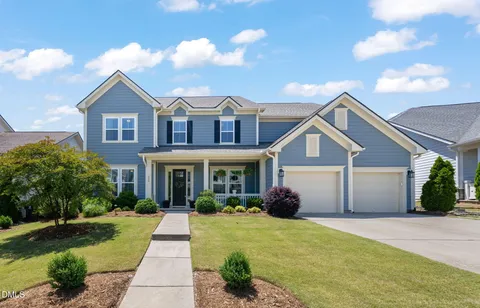 a front view of a house with yard and green space