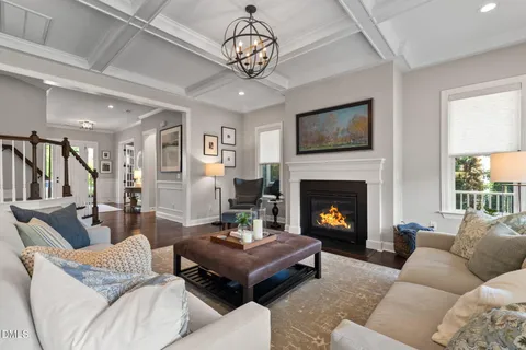 a living room with furniture chandelier and a fireplace