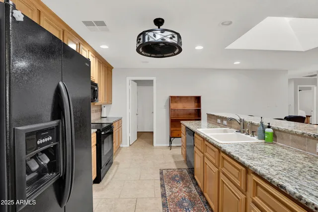 a kitchen with granite countertop stainless steel appliances a stove a refrigerator a sink and cabinets