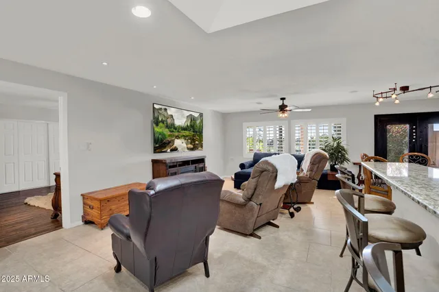 a living room with furniture kitchen view and a chandelier