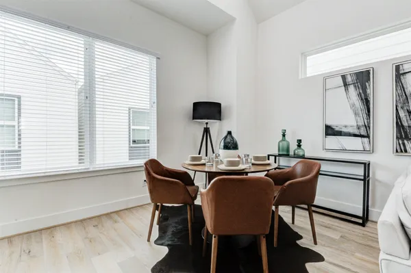 a living room with furniture kitchen view and a large window