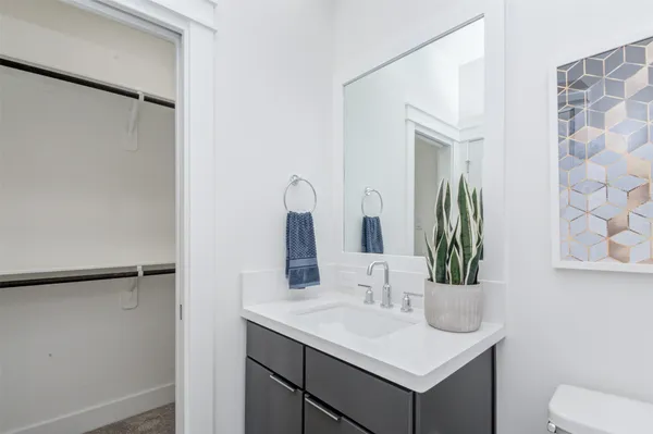 a kitchen with stainless steel appliances a sink a stove a refrigerator cabinets and living room view