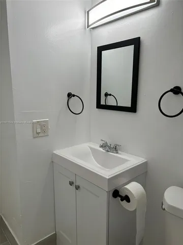a white toilet sitting next to a white cabinet