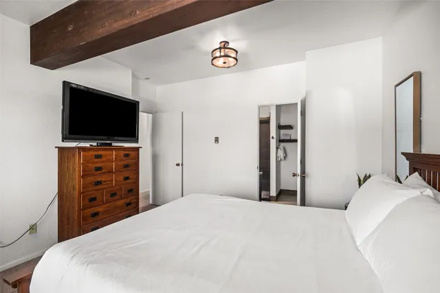 a bedroom with a bed and a flat screen tv