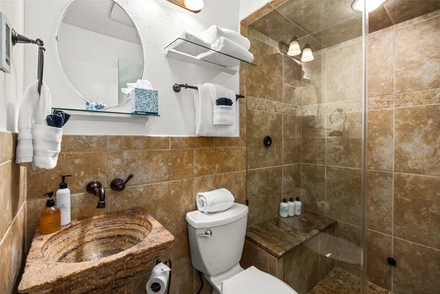 a bathroom with a sink a toilet and shower