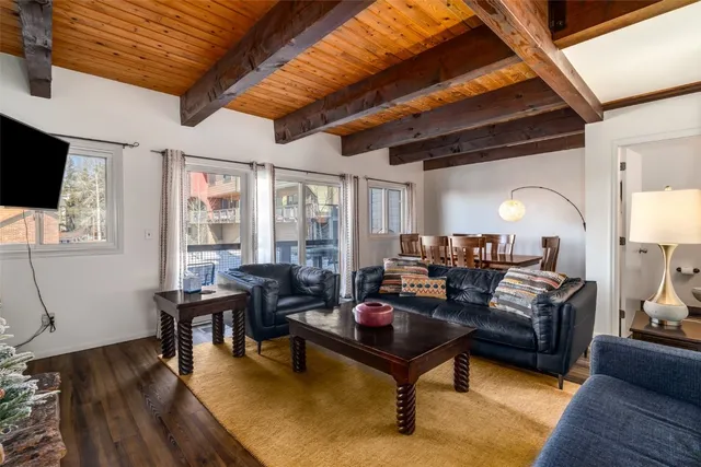 a living room with furniture a wooden floor and a flat screen tv