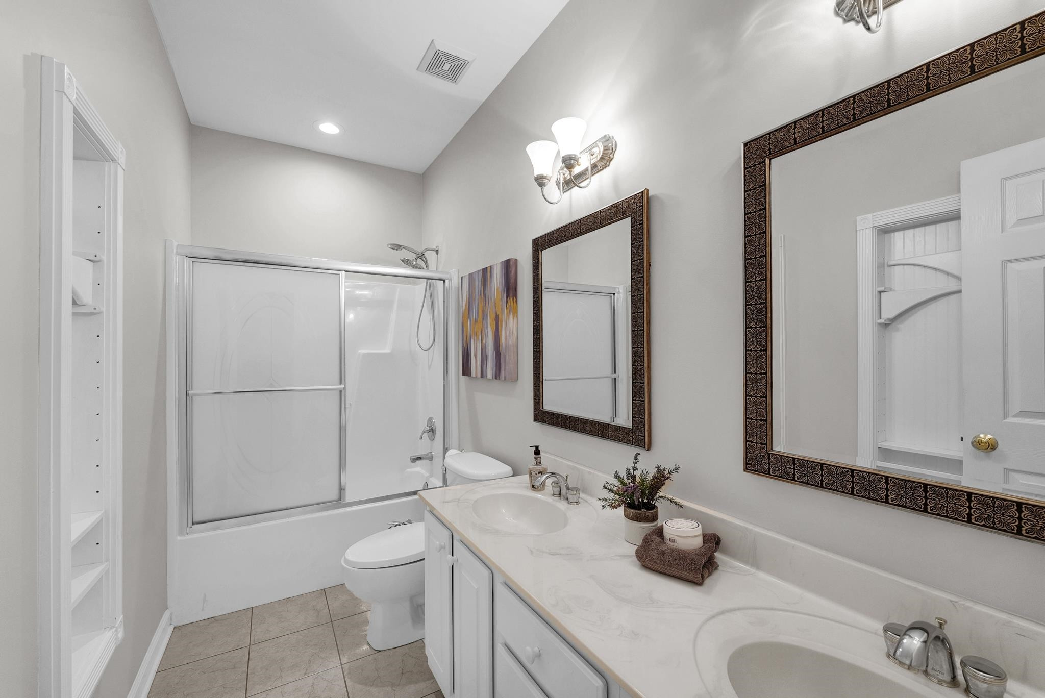 6914 Wexford Woods Trail Raleigh, NC 27613 - Photo 18 of 37 a bathroom with a double vanity sink toilet and mirror