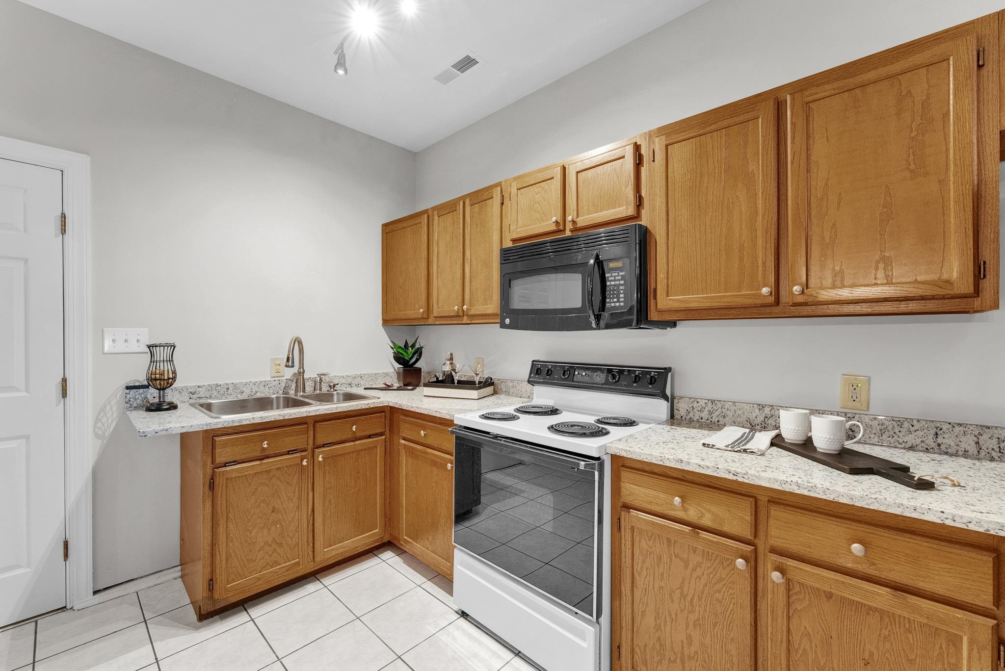 6914 Wexford Woods Trail Raleigh, NC 27613 - Photo 24 of 37 a kitchen with a sink stove and microwave