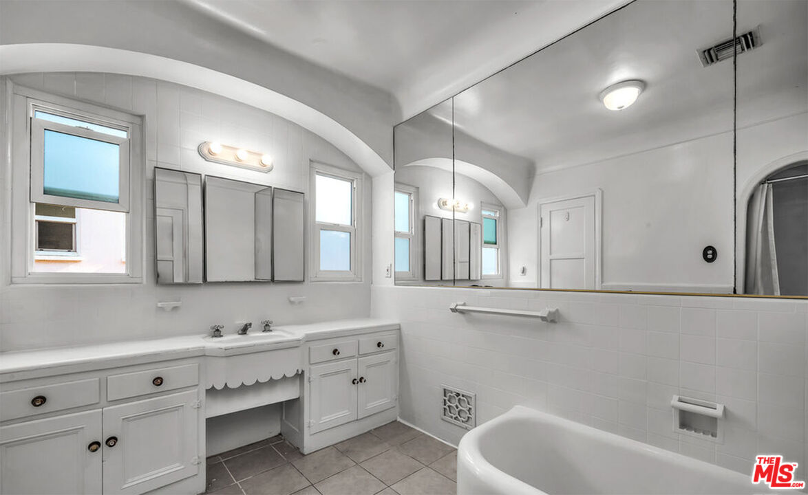 6369 Orange Street Los Angeles, CA 90048 - Photo 14 of 23 a bathroom with a tub sink and mirror