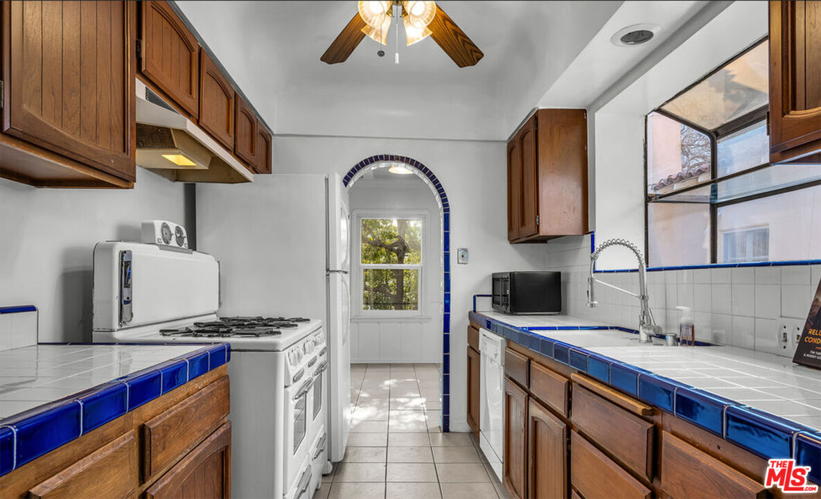 6369 Orange Street Los Angeles, CA 90048 - Photo 2 of 23 a kitchen with stainless steel appliances granite countertop a sink stove and cabinets