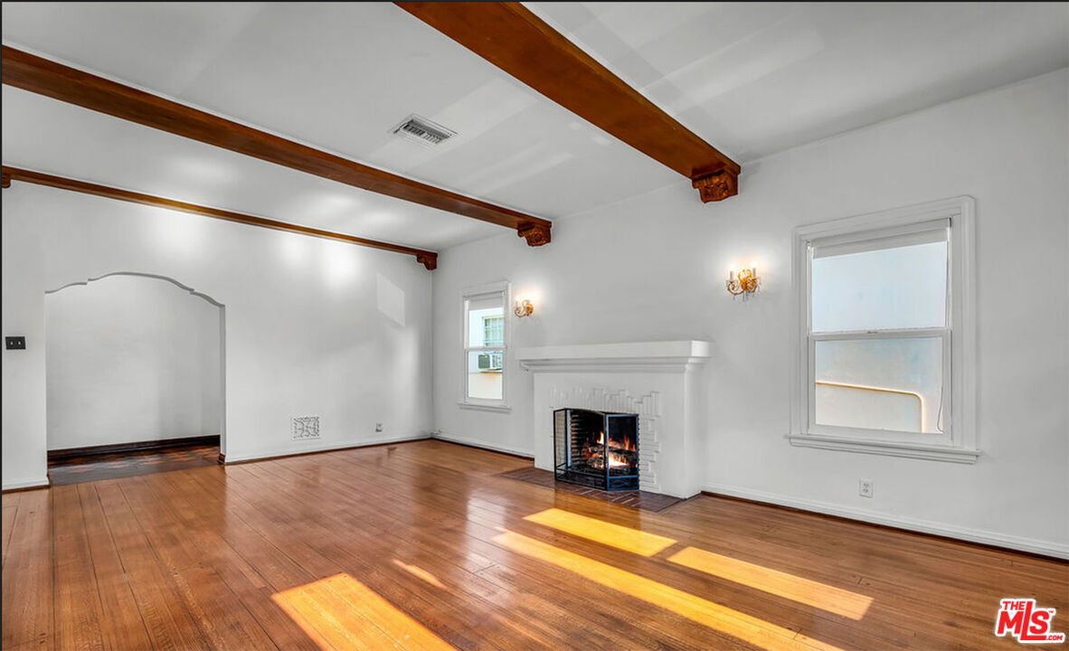 6369 Orange Street Los Angeles, CA 90048 - Photo 21 of 23 a view of empty room with fireplace and wooden floor