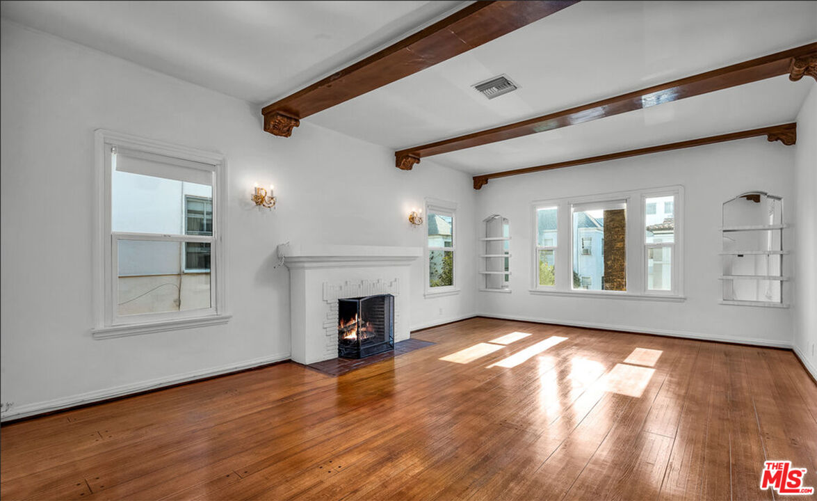 6369 Orange Street Los Angeles, CA 90048 - Photo 3 of 23 a view of empty room with wooden floor and fireplace