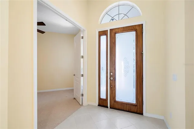 an empty room with windows and chandelier fan