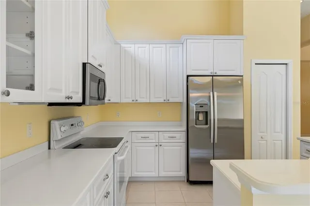 a kitchen with stainless steel appliances granite countertop a refrigerator a sink and a stove