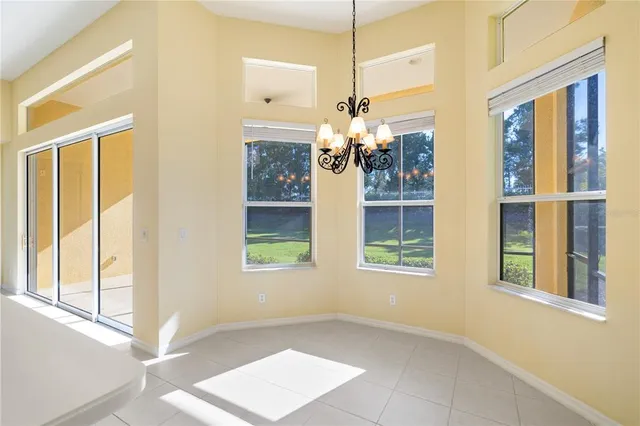 a view of a livingroom with a chandelier fan and windows